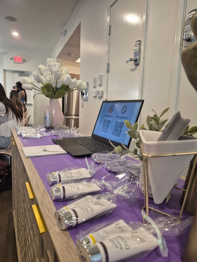 Skin by Brooke product samples on a sponsor table at an ASU sorority event.